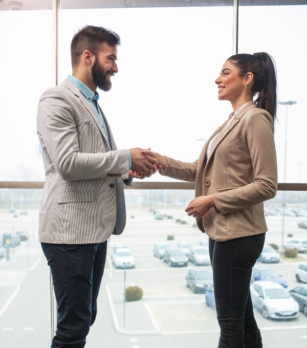 man shaking womans hand smiling